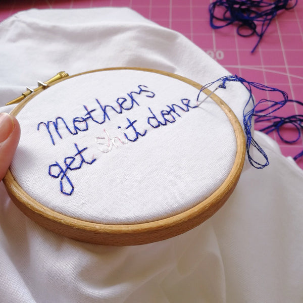 organic cotton white slogan t-shirt, embroidered with 'mothers get shit done' in navy thread. funny gift for new mum