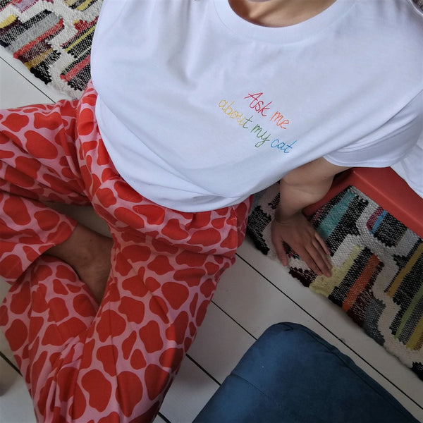 organic cotton white slogan tshirt, embroidered with ask me about my cat in rainbow threads. funny birthday gift for cat mum or cat lover