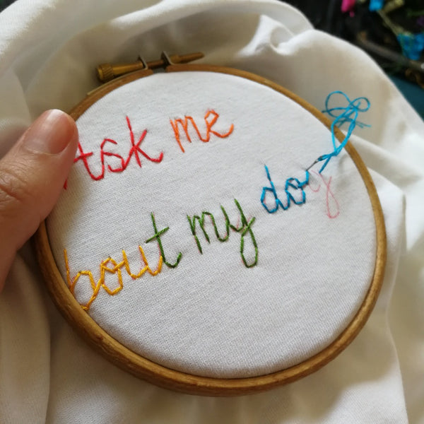 organic cotton white slogan tshirt, embroidered with ask me about my dog in rainbow threads. funny birthday gift for dog mum or dog lover