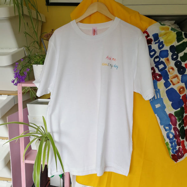 organic cotton white slogan tshirt, embroidered with ask me about my dog in rainbow threads. funny birthday gift for dog mum or dog lover