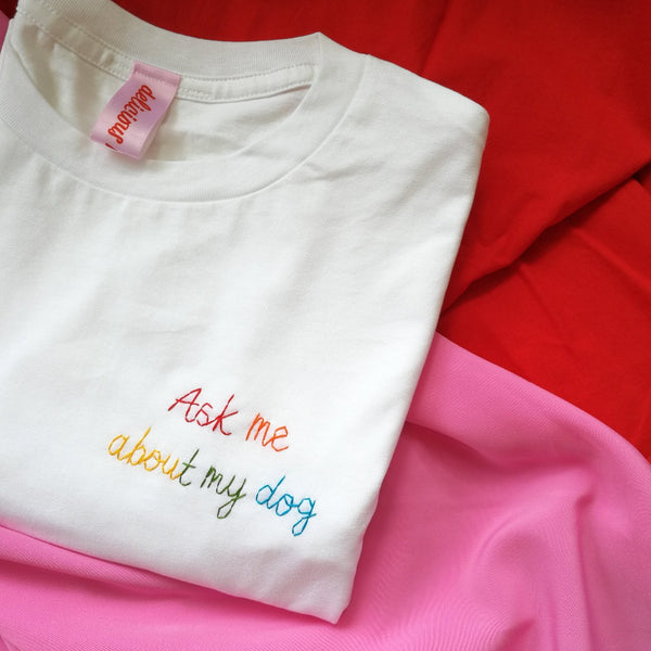 organic cotton white slogan tshirt, embroidered with ask me about my dog in rainbow threads. funny birthday gift for dog mum or dog lover