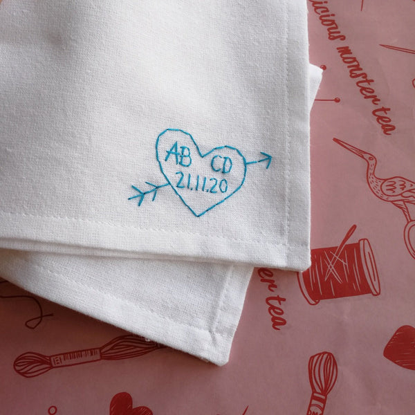 personalised handkerchief gift, made from white organic cotton, hand embroidered with custom heart, initials of couple and wedding or anniversary date