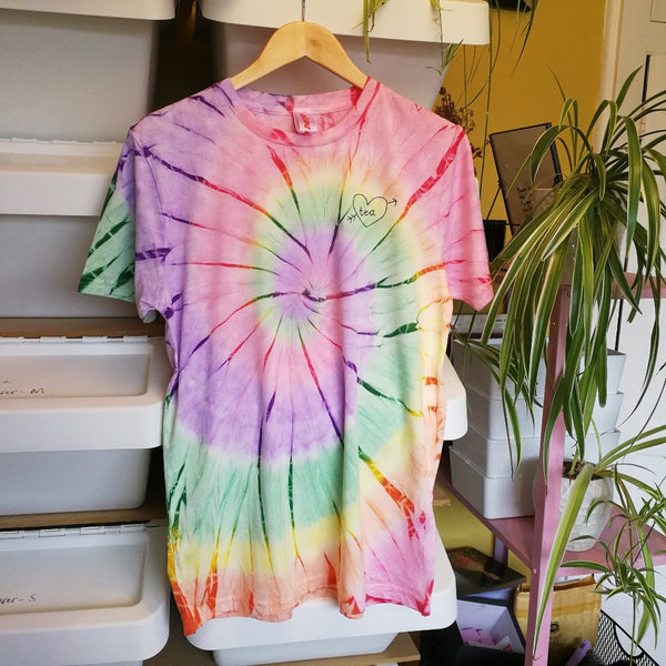 hand embroidered t-shirt, made from rainbow tie-dye organic cotton, and hand embroidered with a personalised love heart 'tea', as a funny gift for vegan tea lovers