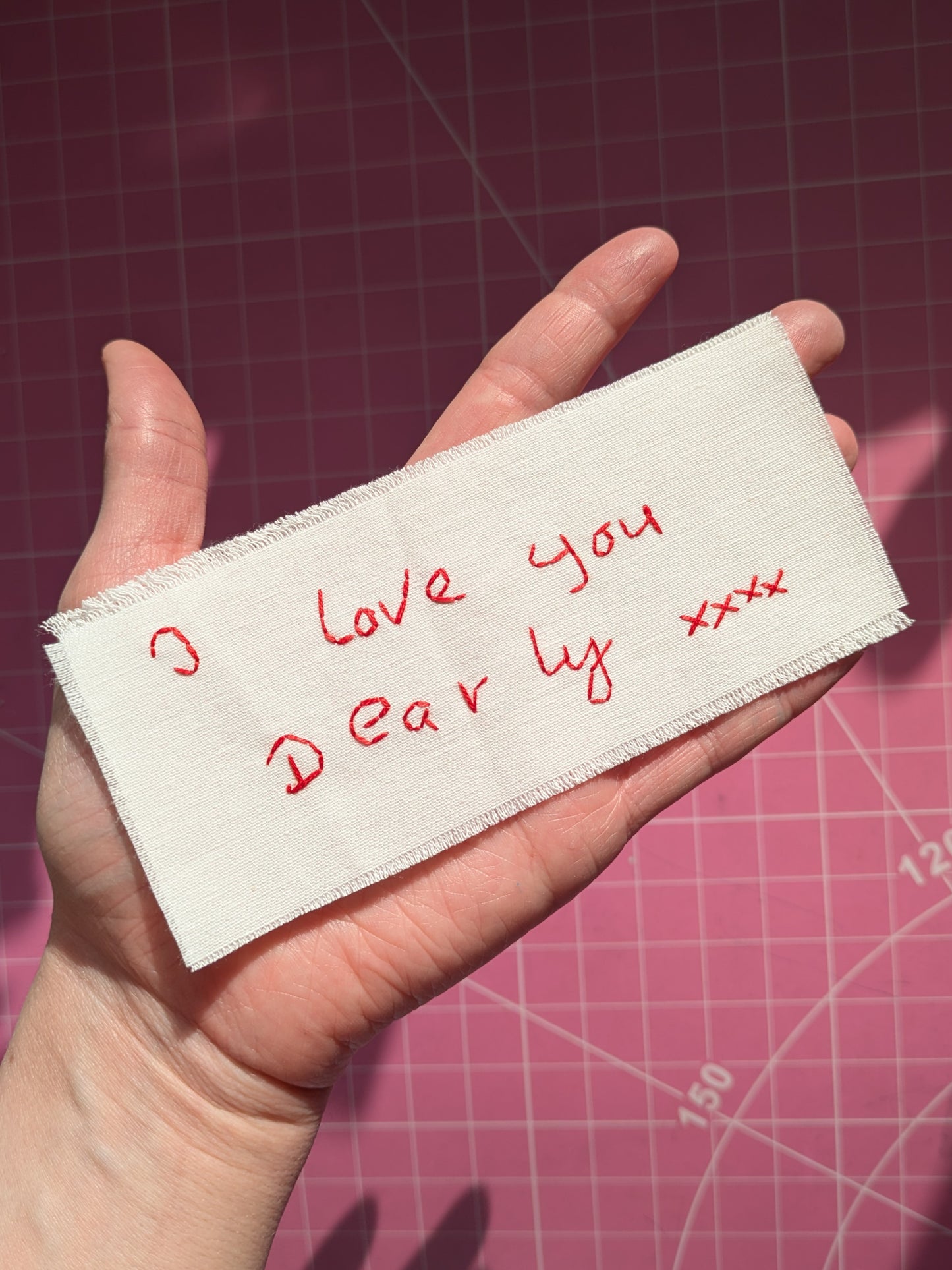 hand embroidered handwritten message on cotton with a raw edge made to be framed