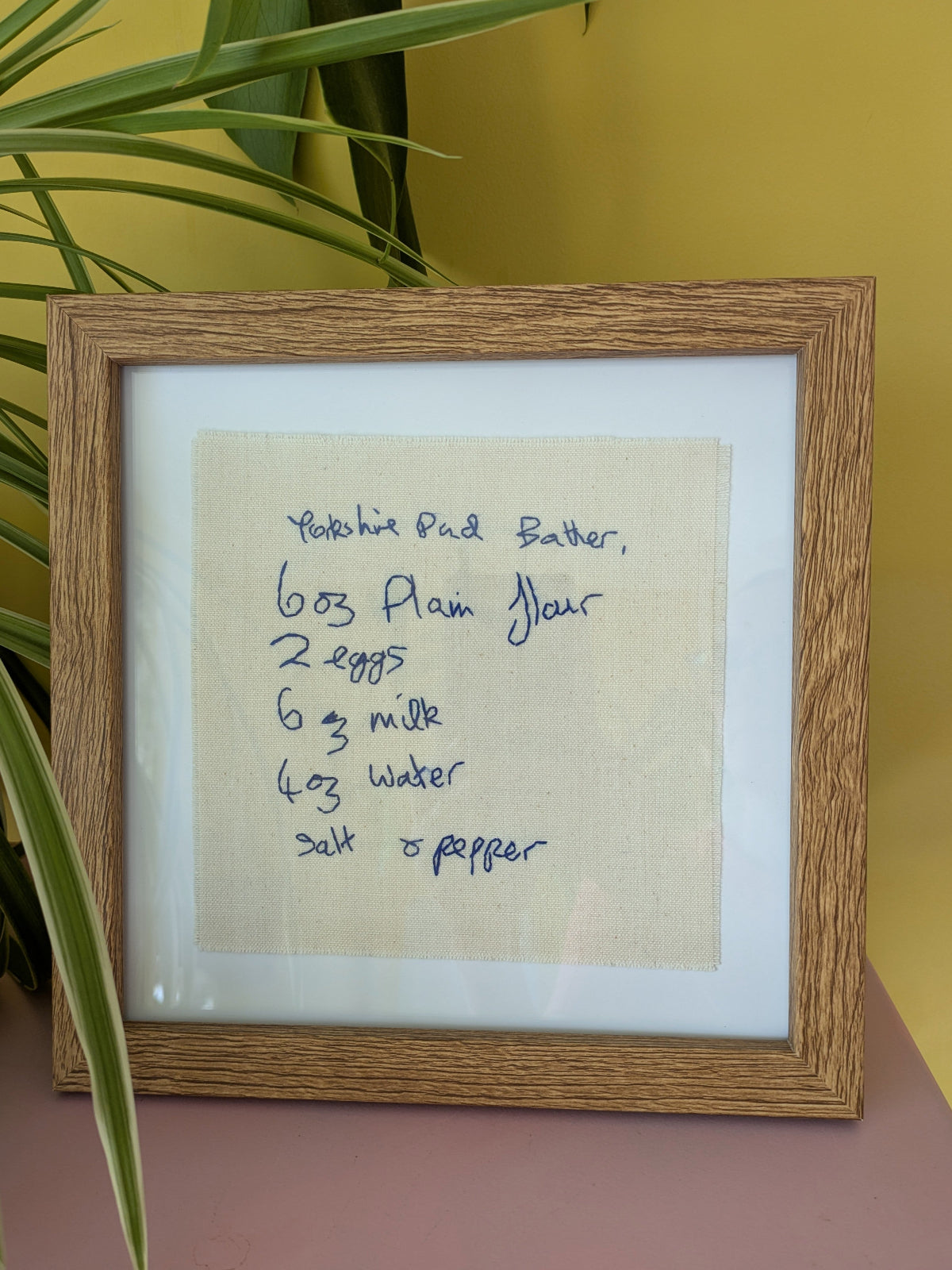 handwritten family recipe hand embroidered on cotton, styled in a wooden frame