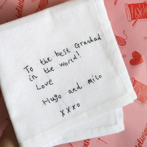 White napkin with handwritten message on a pink background