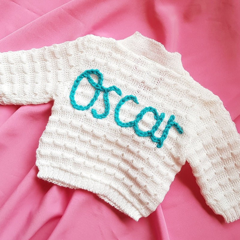 personalised baby name cardigan, embroidered with new baby girl's name in blue knit