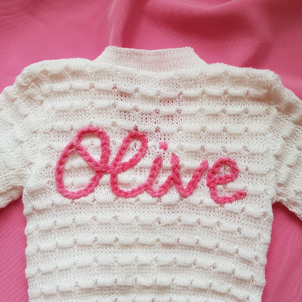 personalised baby name cardigan, embroidered with new baby girl's name in pink knit