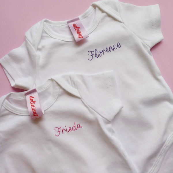 personalised baby grow, made from white organic cotton, and hand embroidered with baby's name, as a gift for new born baby