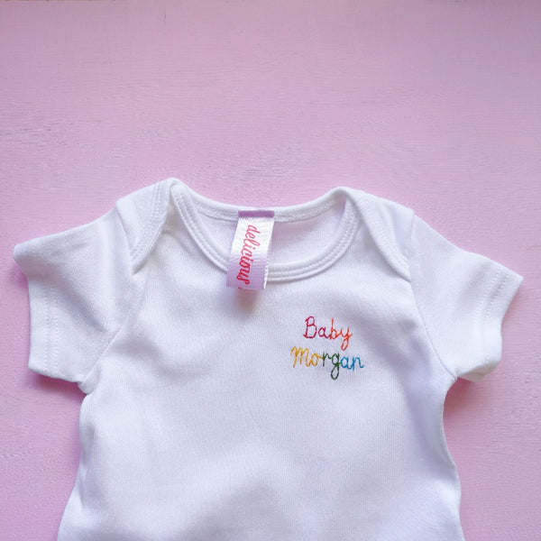 personalised baby grow, made from white organic cotton, and hand embroidered with baby's name, as a gift for new born baby