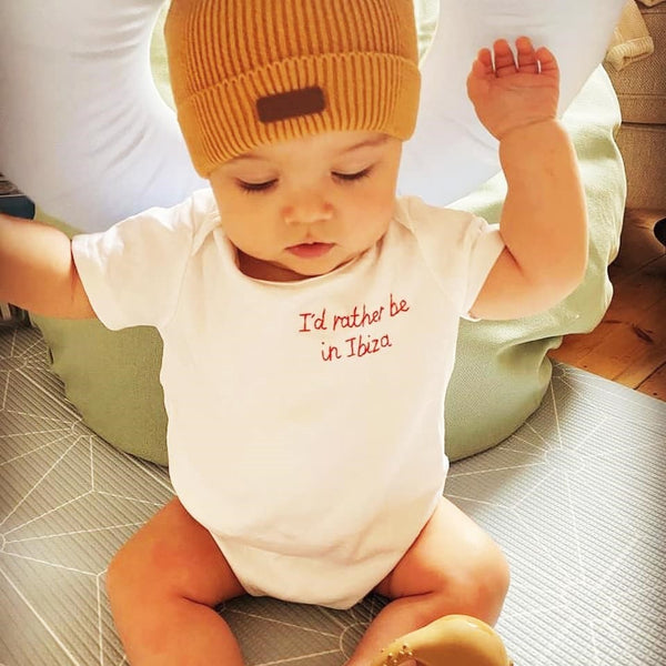 personalised baby grow, made from white organic cotton, and hand embroidered with 'I'd rather be in Ibiza', as a funny gift for new born baby