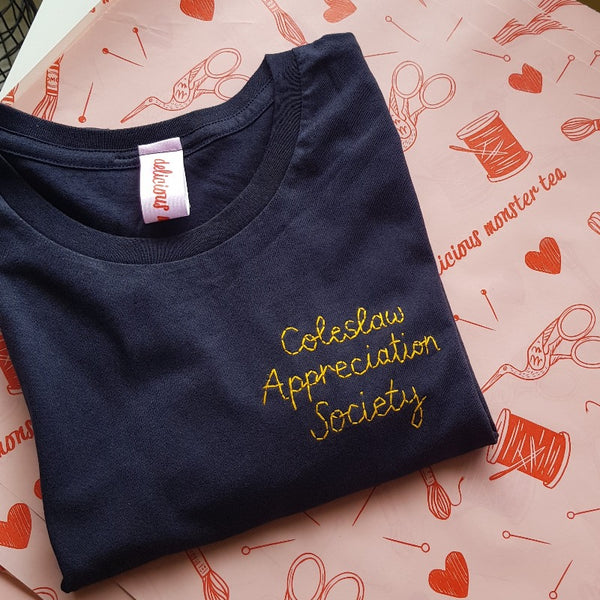 men's personalised t-shirt, hand embroidered with custom slogan 'coleslaw appreciation society' in yellow thread, as funny christmas gift or birthday gift for him