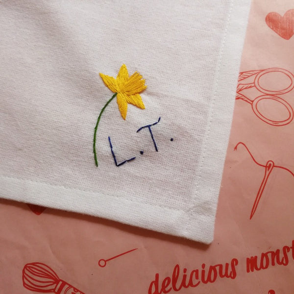 personalised handkerchief, made from white organic cotton, hand embroidered with daffodil and initials or monogram, as birthday gift for sister