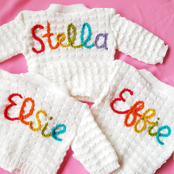 personalised baby name cardigan, embroidered with new baby girl's name in rainbow knit