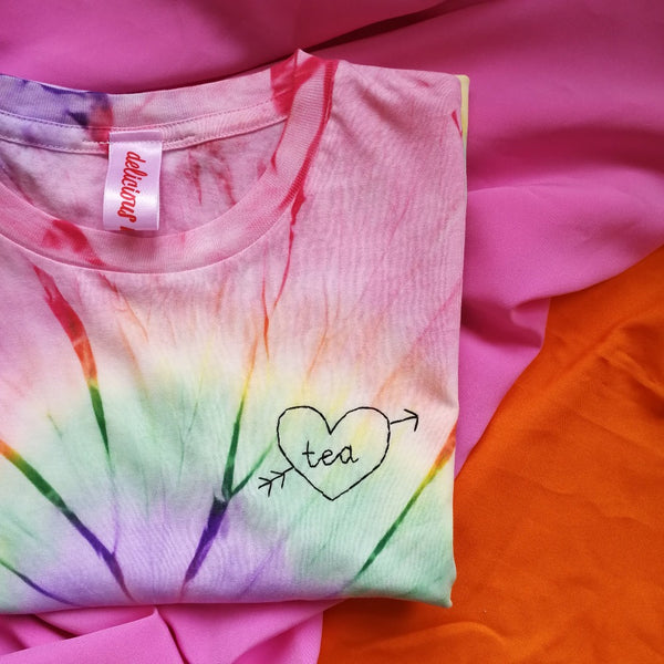 hand embroidered t-shirt, made from rainbow tie-dye organic cotton, and hand embroidered with a personalised love heart 'tea', as a funny gift for vegan tea lovers