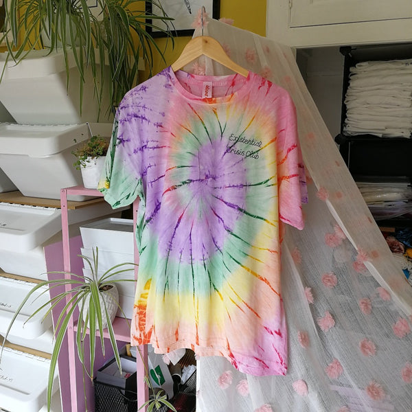 unisex rainbow tie-dye personalised t-shirt, made from organic cotton, and hand embroidered with custom slogan 'existential crisis club' in black thread, as funny gift for anxious millennial